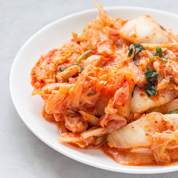 Kimchi cabbage. Korean appetizer on a white plate, square format - Photo, Image