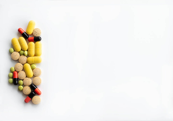 左端には多色の錠剤とさまざまな形のカプセルがあり、テキストトップビューの場所があります。. - 写真・画像