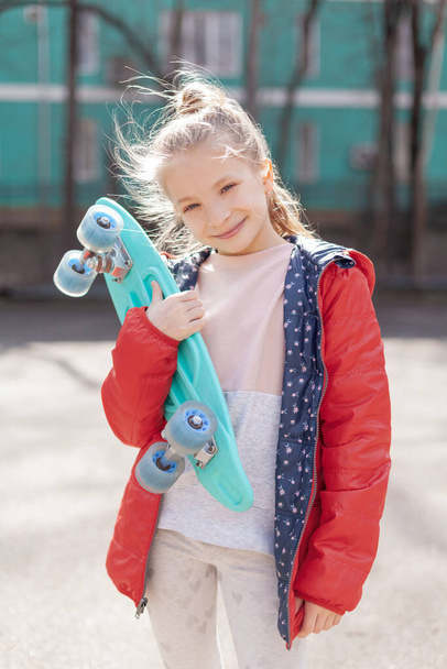 Smiling teen girl with green skateboard in sport park outdoor - Foto, Imagen