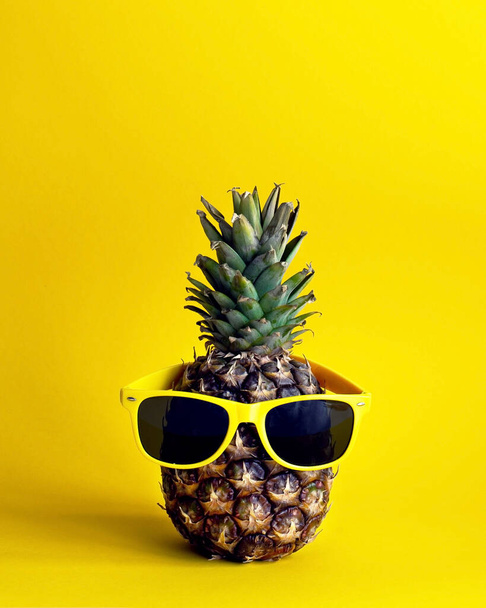 Ananas auf gelbem Hintergrund mit gelben Gläsern - Foto, Bild