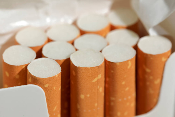 Several cigarettes in an already incomplete pack. These are filter cigarettes. - Foto, Imagem