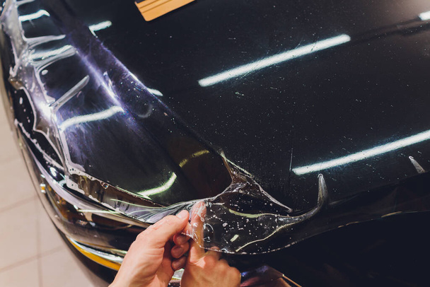 Transparent film, car paint protection, wrapping specialis. Car detailing. Selective focus. - Valokuva, kuva