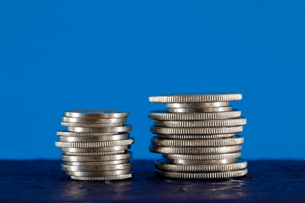 Дві купи швейцарських грошей, показаних на синьому фоні. Поверхня, на якій розміщені ці монети, темно-синя.. - Фото, зображення