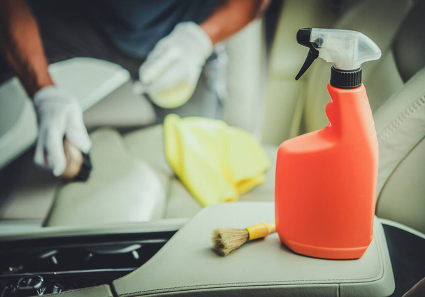 Hombres caucásicos limpiando el interior del vehículo usando detergente higiénico especializado. Mantenimiento interior del coche
. - Foto, imagen