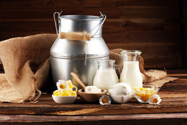 Milchprodukte. leckere gesunde Milchprodukte auf einem Tisch an. Mozzarella in einer Schüssel, Quarkschüssel, Butterwirbel und Glasflasche  - Foto, Bild