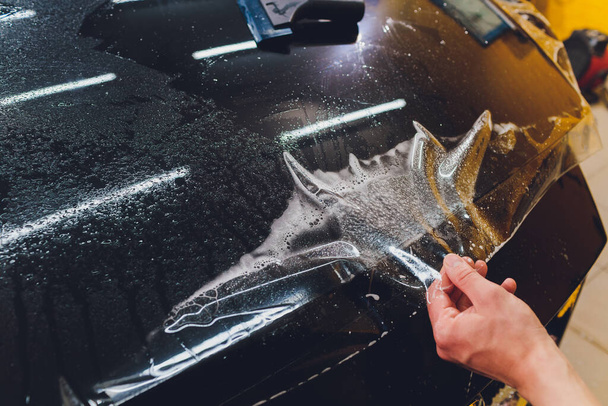 Transparent film, car paint protection, wrapping specialis. Car detailing. Selective focus. - Fotoğraf, Görsel