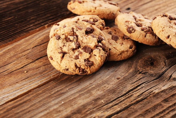 Chocolate cookies on wooden table. Chocolate chip cookies shot on wood - Photo, Image
