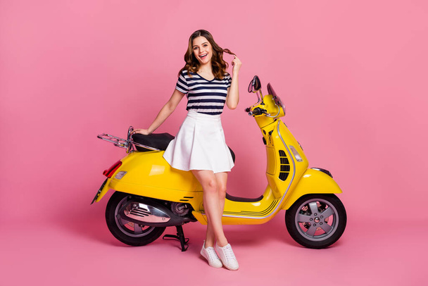Portrait of her she nice attractive lovely cheerful cheery girl sitting on moped playing with curl rent rental service buy credit loan sale isolated on pink pastel color background - Photo, Image