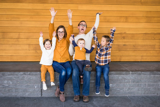 Young caucasian family celebrates with arms in air - Photo, Image