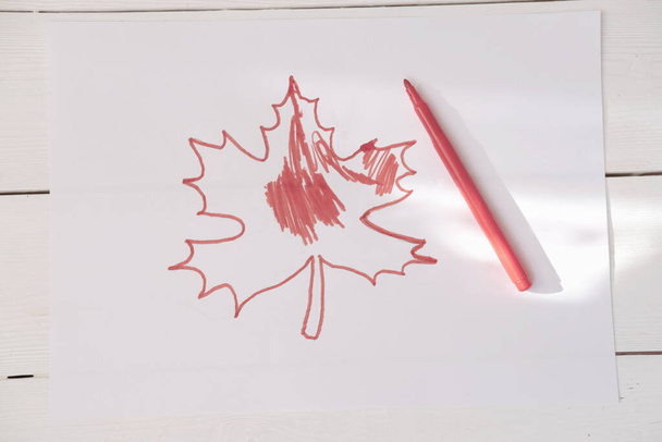 Día de Canadá. Hoja de arce rojo dibujada a mano por niño. niños dibujando para la selebración del día de Canadá. Símbolo canadiense dibujado en un papel. Día Nacional de los Patriotas, Día Cívico, Provincial, del Trabajo y del Descubrimiento
 - Foto, imagen