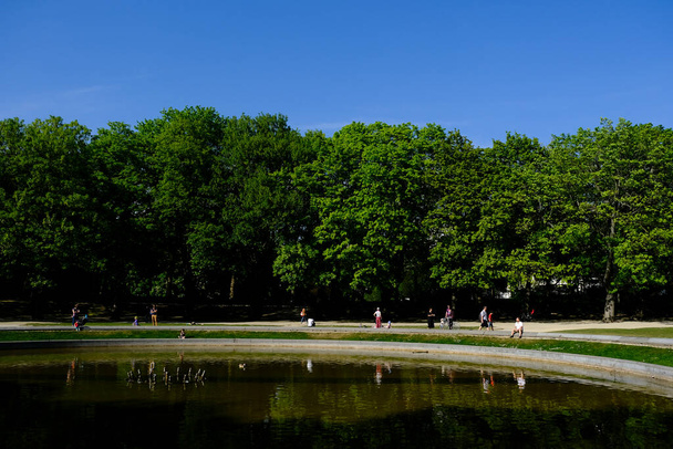  Menschen spazieren und genießen den sonnigen Tag in einem Park, während die Ausbreitung der Coronavirus-Krankheit (COVID-19) in Brüssel, Belgien, am 24. April 2020 weitergeht. - Foto, Bild