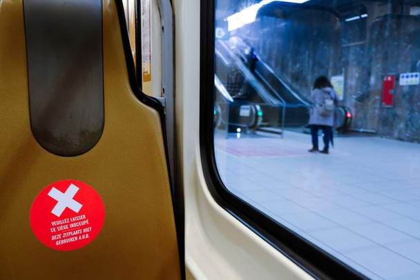 Sedadla v bruselské veřejné dopravě označená samolepícími štítky, aby se zajistilo, že cestující budou 28. dubna 2020 v Bruselu v Belgii dodržovat odpovídající sociální odstup 1,50 metru. - Fotografie, Obrázek