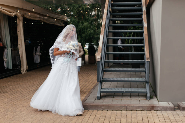 レースのドレスとブライダルベールで花嫁は彼女の手の花束と結婚式に行く。新婚の肖像画。ウェディング写真 - 写真・画像