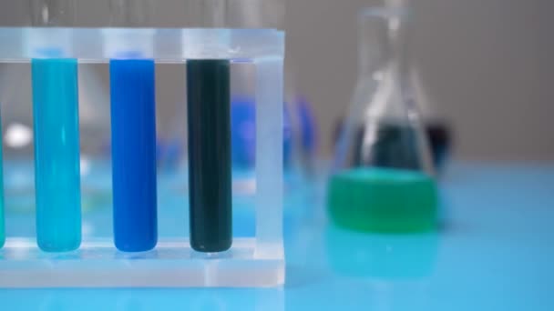 Nahaufnahme-Reagenzgläser mit farbigen Flüssigkeiten stehen auf dem Prüfstand. Kamerabewegung entlang - Filmmaterial, Video