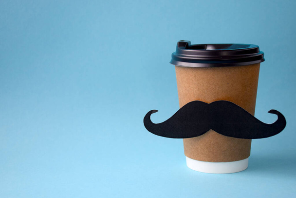 La tasse en papier de café chaud pour aller avec moustache de papier sur fond bleu
 - Photo, image