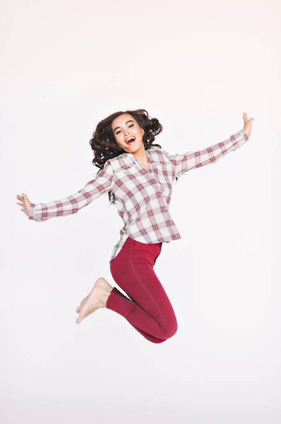 Surprised happy woman in a jump. Close-up portrait of a woman jumping. Emotional girl on a white background. - Photo, image