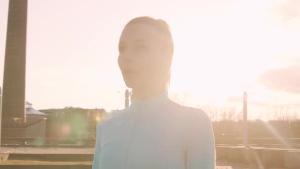 Young, beautiful and sporty woman having evening training outdoor. Urban sunset background. Fitness and sport concept. - Materiał filmowy, wideo