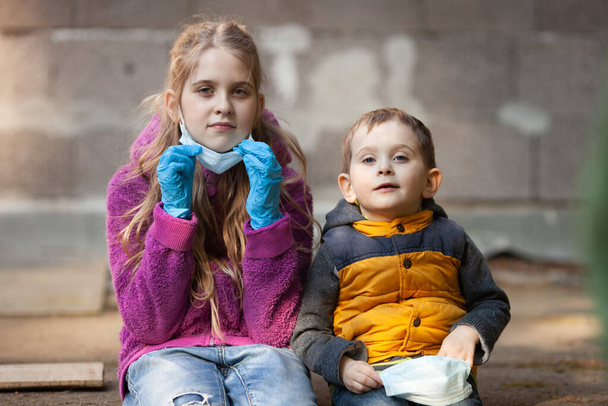 Chica y niño quitándose máscaras protectoras esperando el final de la cuarentena del coronavirus. Niños cansados del encierro y del aislamiento social. # LockdownArt
 - Foto, Imagen