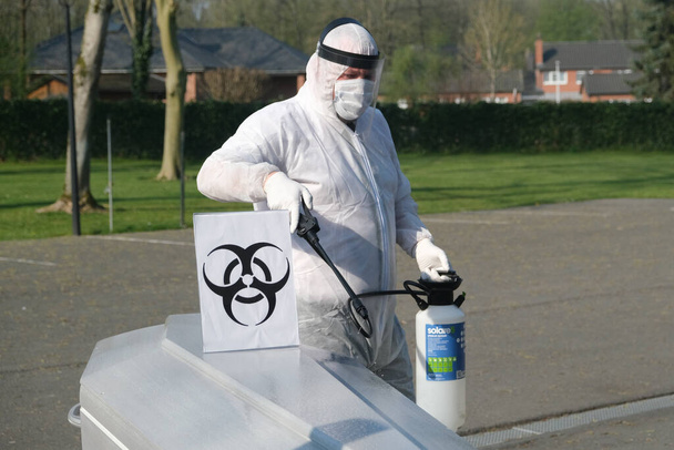 Trabajadores mortuorios con guantes y mascarilla protectora desinfecta el ataúd de una víctima del COVID-19 en la morgue de la compañía en Charleroi, Bélgica, el 9 de abril de 2020
. - Foto, imagen