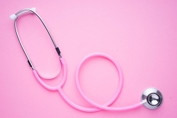 Frauen im Konzept der Gesundheitsindustrie. Ein rosafarbenes Strethoskop auf rosa Hintergrund. - Foto, Bild