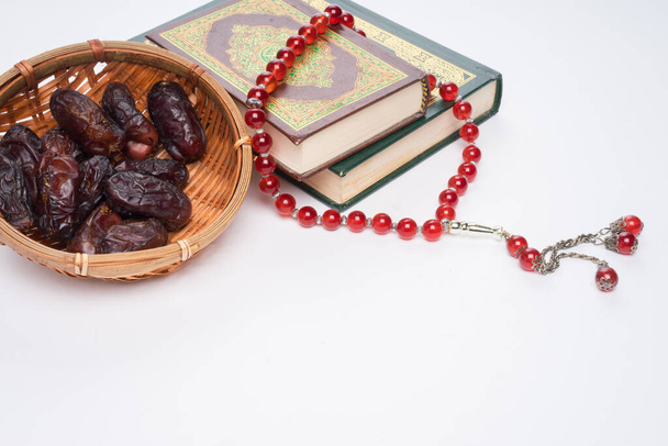 Πίστη στο Ισλάμ έννοια. Το ισλαμικό ιερό βιβλίο Quran ή Kuran με χάντρες κομπολόι ή tasbih απομονώνονται σε λευκό φόντο. - Φωτογραφία, εικόνα