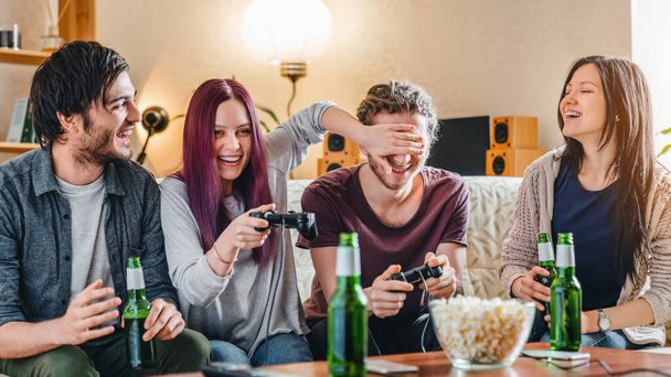 Young group of friends having fun while playing video games at home - Photo, image