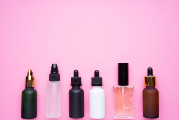 Creative arrangement of cosmetics products on pink background. - Фото, изображение
