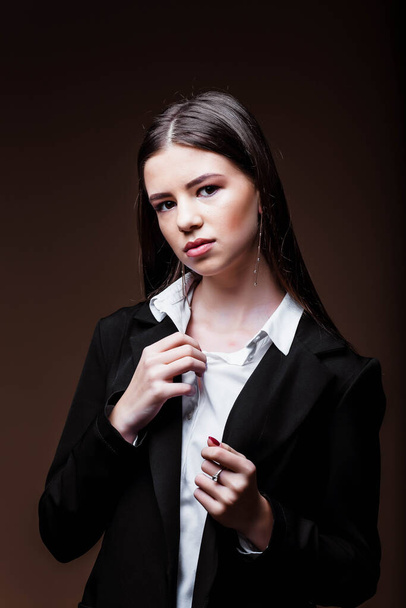 Portrait of a businesswoman in the studio. Beauty and fashion. Girl businessman. Portrait of a girl. Beautiful female face with perfect genuine skin.Beauty.Femininity. Girl in a white shirt and jacket - Fotoğraf, Görsel