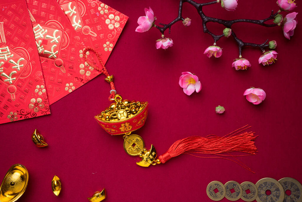 Китайские новогодние украшения на красном фоне с разнообразными праздничными украшениями. Китайские иероглифы означают богатство, процветание и удачу. Плоский лежал
. - Фото, изображение