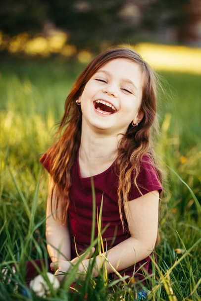 Primer plano retrato de risa divertida joven niña caucásica al aire libre. Lindo niño adorable divirtiéndose afuera. Feliz estilo de vida infantil. Emoción positiva sincera
.  - Foto, Imagen