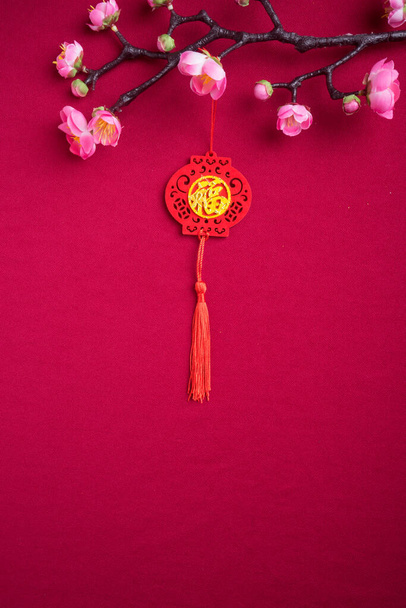 Čínská novoroční dekorace s červeným pozadím s pestrou festivalovou výzdobou. Čínské znaky znamenají hojnost bohatství, prosperity a štěstí. Plocha. - Fotografie, Obrázek