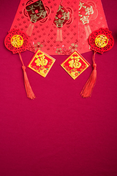 Chinese New Year decorations with red background with assorted festival decorations. Chinese characters means abundant of wealth, prosperity and luck. Flat lay. - Photo, Image
