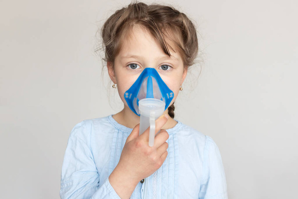Close-up Caucasian girl with mask for inhalation. Prevention of bronchitis, inhalation at home. Place for text. - Photo, image
