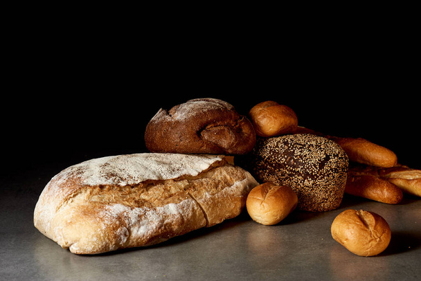 Freshly baked bakery products on a gray surface. Black background. - Photo, Image