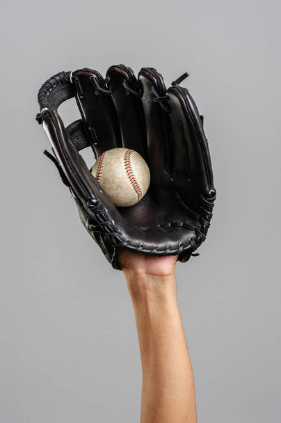 catching baseball with leather baseball glove over gray background - Foto, afbeelding