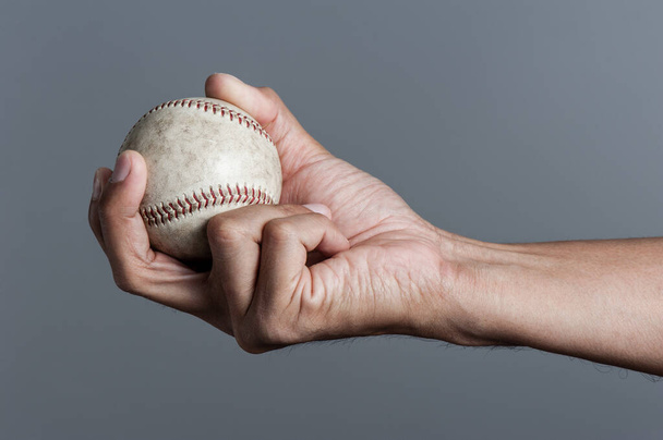closeup baseball in man's hand, isolated over background - Foto, Imagem