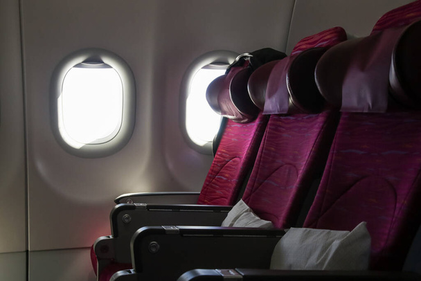 Uçak kabininde boş koltuklar ve mavi gökyüzü manzaralı pencereler - Fotoğraf, Görsel