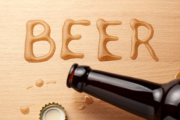Butelka po piwie i rozlany napój na stół - Zdjęcie, obraz
