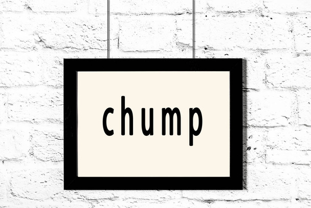 Marco negro colgando en la pared de ladrillo blanco con la inscripción chump
 - Foto, imagen