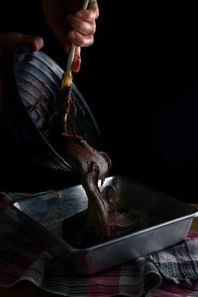 Foto de la masa de brownies de chocolate en una bandeja para hornear
. - Foto, Imagen