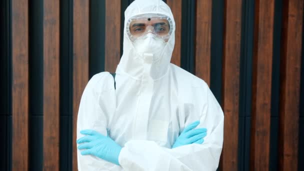 Portrait of disinfector in protective suit standing outdoors during covid-19 pandemic - Filmati, video