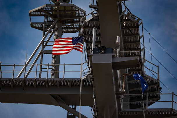 Die amerikanische Flagge weht vom Mast eines US-Flugzeugträgers. - Foto, Bild