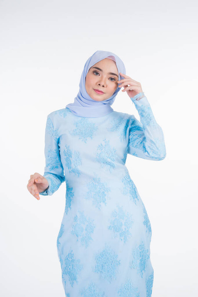 Gyönyörű muszlim női modell visel pasztell kék modern kurung hidzsáb, városi életmód ruházat muszlim nők elszigetelt fehér háttérrel. Szépség és hidzsáb divat koncepció. Félhossz - Fotó, kép