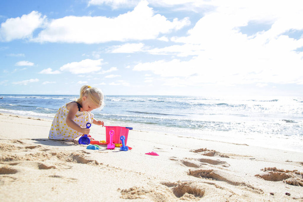 Vacances d'été. Adorable jeune fille jouant avec des jouets de plage sur la plage de sable
. - Photo, image