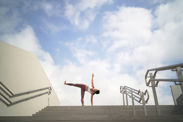 suivant la tendance de faire du yoga dans les espaces publics ouverts, asiatique dame chinoise faire du yoga sur les escaliers
 - Photo, image