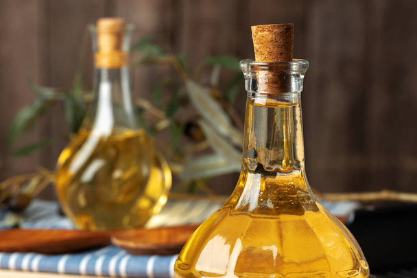 Olive oil bottle on wooden table, close up. - Photo, image