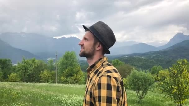 jóképű férfi alkalmi ruhák sétál a hegyek között a nyári napon   - Felvétel, videó