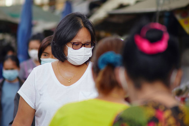 Multidão com mulheres asiáticas em máscaras para proteção contra vírus em ruas movimentadas do mercado para proteção contra o vírus da corona
 - Foto, Imagem