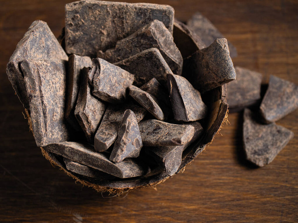 Naturalna czekolada bez cukru z tartego ziarna kakao, w opakowaniach ekologicznych na ciemnym tle - Zdjęcie, obraz