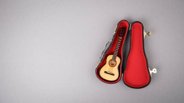 Gray background with copy space. Wooden Guitar with black Box - Photo, Image